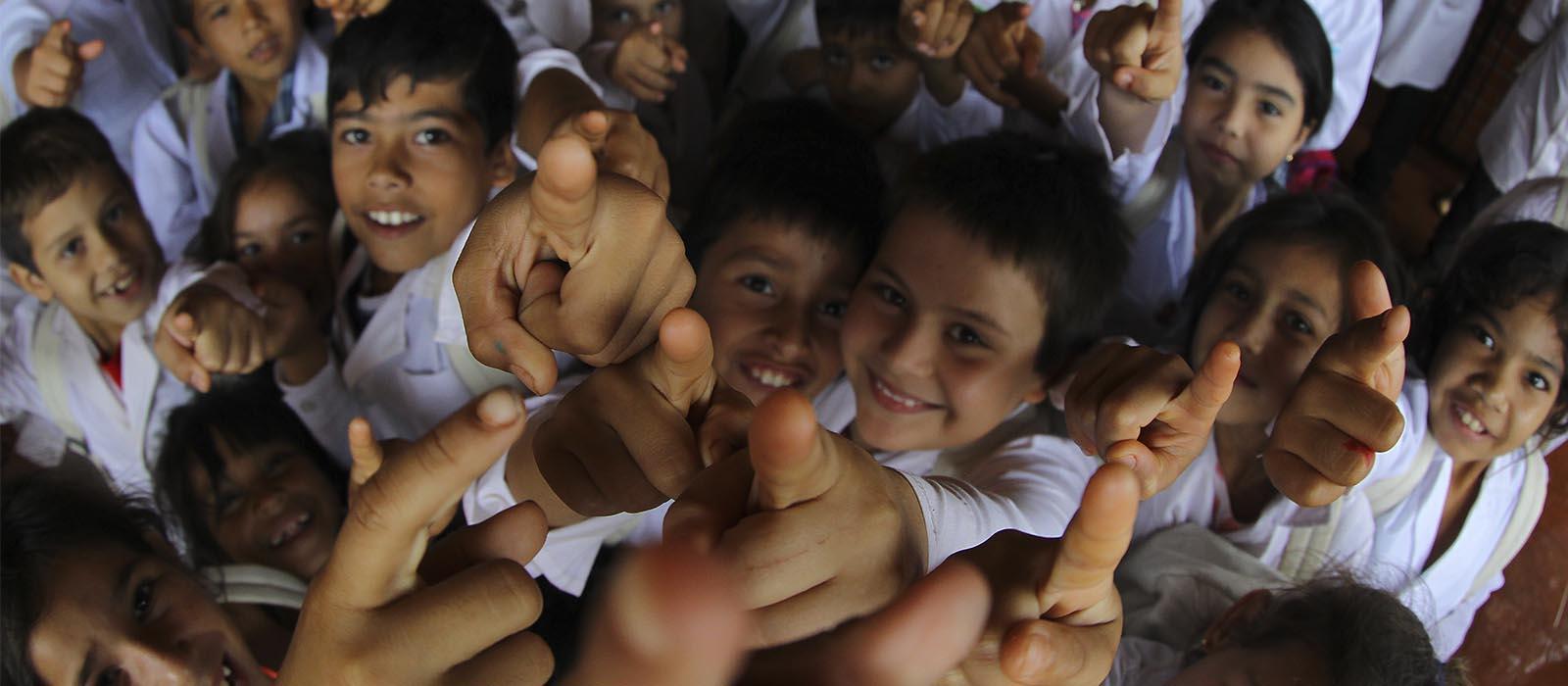 Grupo de niños señalando a la cámara